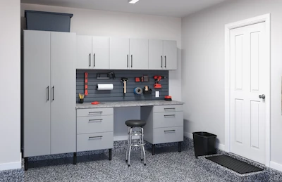 Peak Cabinets garage storage with white cabinetry, work bench, drawers, and wall-mounted tool organization.