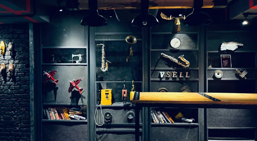 Peak Cabinets dark industrial garage cabinetry with glass doors, tool storage, collectibles, and red metal accents.